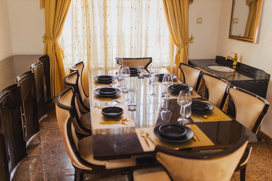 Dining room with polished table, sideboard and gold tap